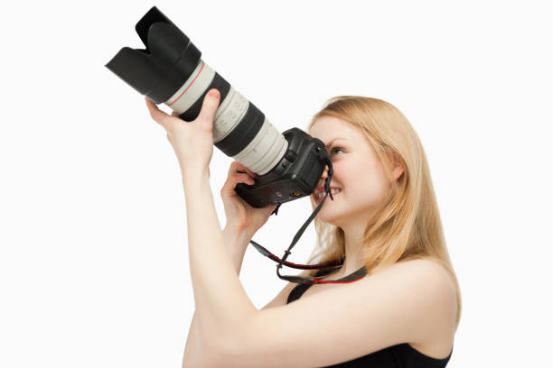 istock Woman aiming with a SLR camera while smiling 827442400
