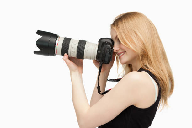 istock Woman smiling while holding a SLR camera 827442412