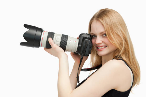 istock Woman looking at the camera while holding a camera 827443026