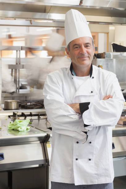 istock Chef leaning at counter in busy kitchen 827444530