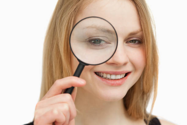 istock Woman placing a magnifying glass on her eye 827444554
