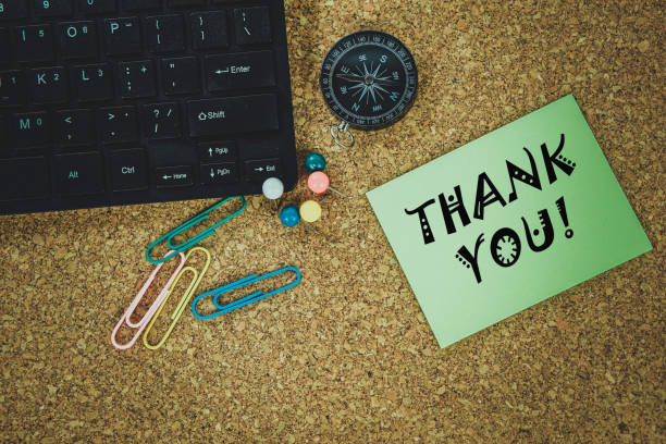 istock the text THANK YOU! on a notebook, over wooden table and compass 827446044