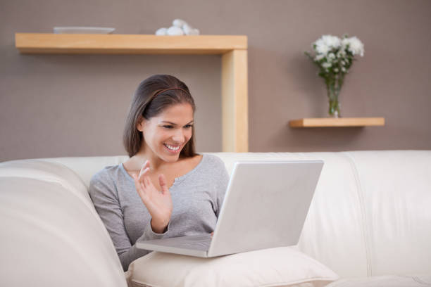 istock Cheerful woman with her notebook on the sofa 827448600