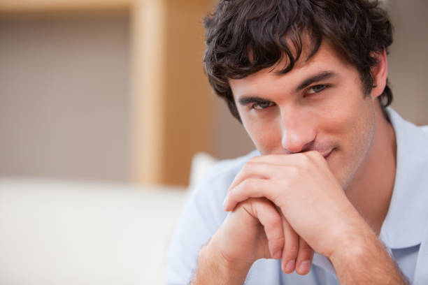 istock Man with hands folded in the living room 827449072