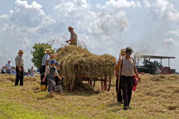 Four figures made out of straw bales, man, woman, boy, girl, father, mother, daughter, son, on a meadow