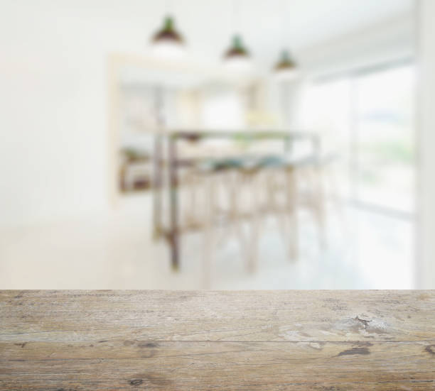 istock wooden table top with blur of modern dining table in dining room 827457166