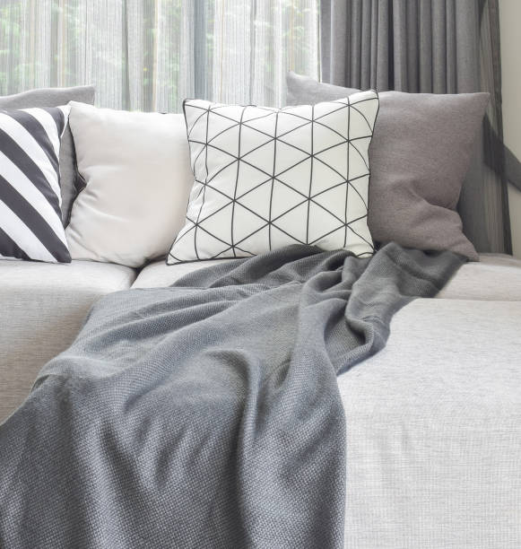 istock Light gray L shape sofa with varies pattern and white pillows in modern living corner 827461492