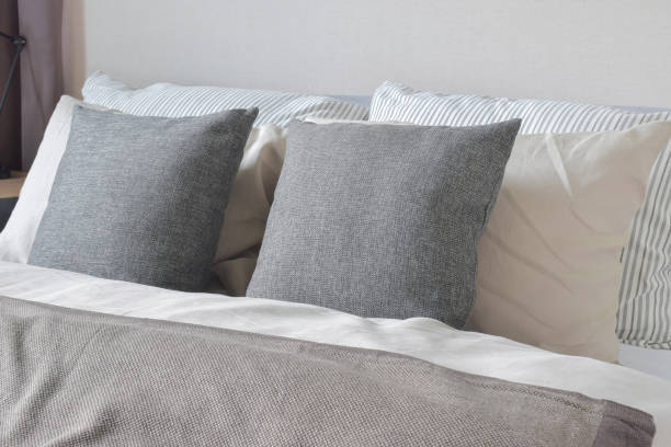 istock Dark gray and off white pillows setting on bed 827461526