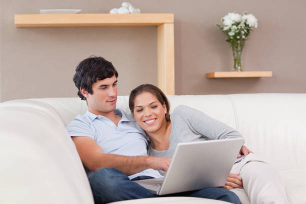 istock Couple with their laptop on the couch 827464116