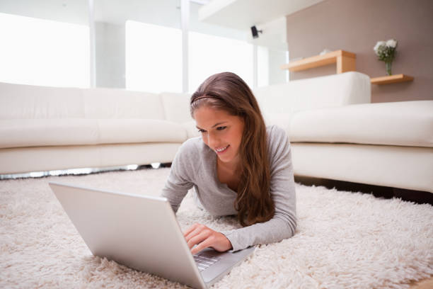 istock Woman lying with laptop on the carpet 827464296