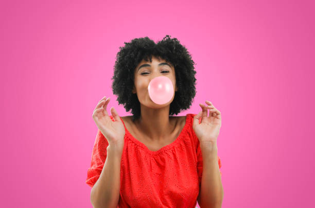 istock Young woman in dress blowing bubble 827464730