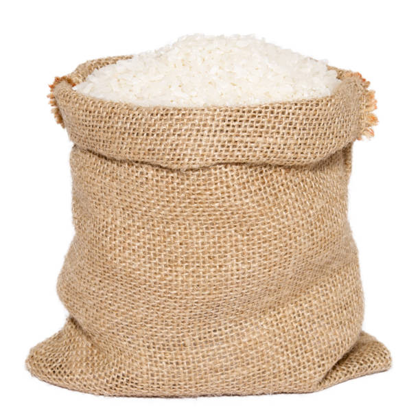 White rice in burlap sack bag isolated on white background White rice in burlap sack bag isolated on white background sack stock pictures, royalty-free photos & images