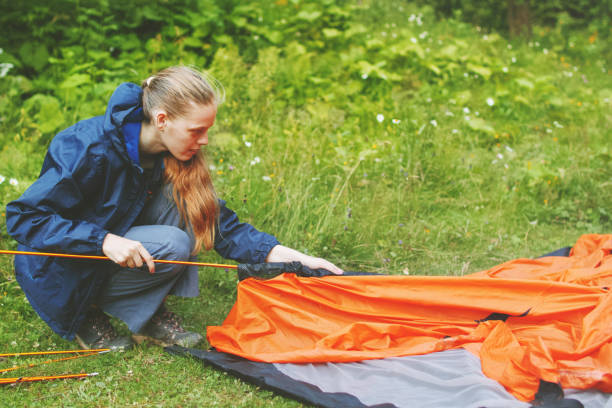 istock Young woman setting up a tourist tent 827468870