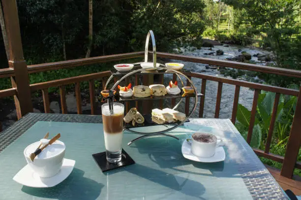 Etagere with cake and coffee at beautiful river