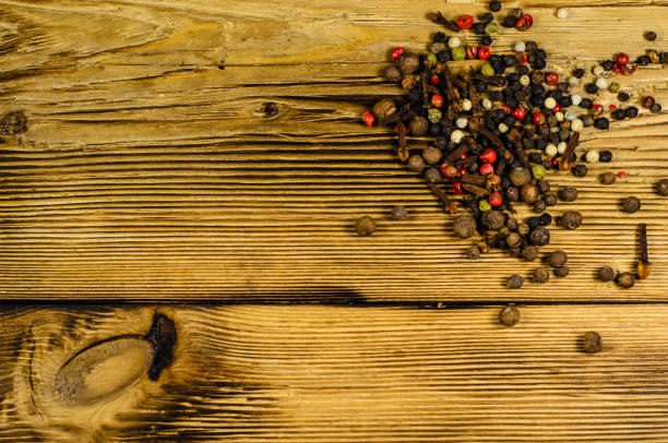 istock Different pepper spices on wooden table. Top view 827470402