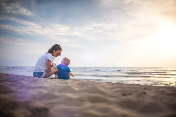 istock Mother and son on the beach on sunset 827472936
