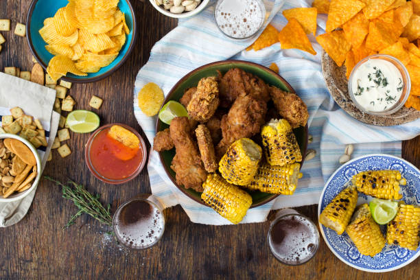 istock Fried chicken, beer and snacks to beer on wooden table, top view 827473632