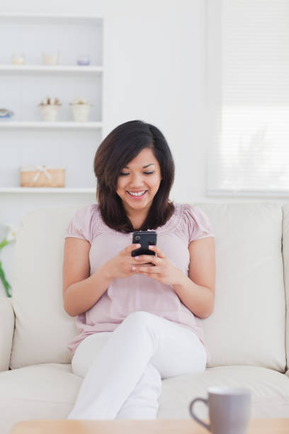istock Woman smiling while holding a phone 827473946