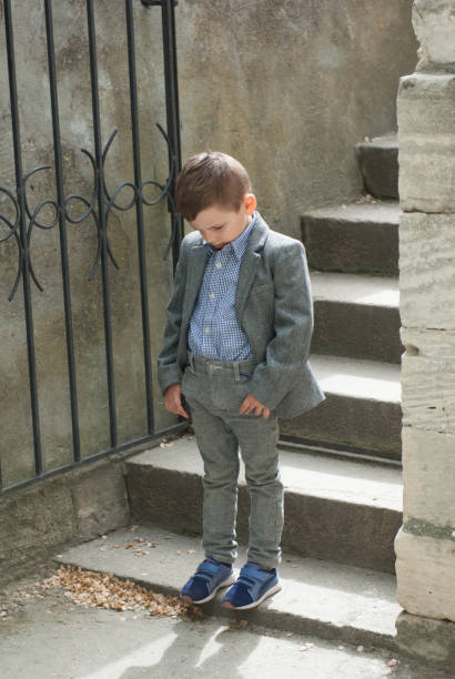 istock Sad handsome little boy in suit 827474330
