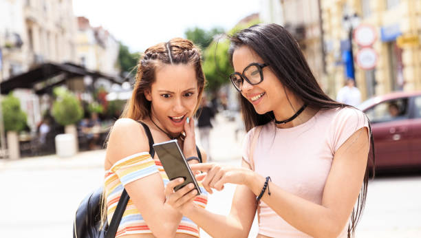 istock Girls hanging out and using smart phone on street 827486092