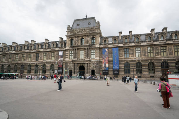 Paris, France. July 27, 2017. Tourists walk in front of the pyramids and  Louvre Museum in Paris