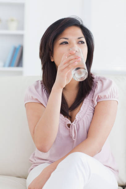 istock Woman drinking water from a glass 827493972
