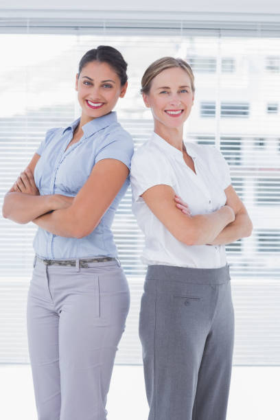 istock Cheerful businesswomen standing back-to-back 827494864