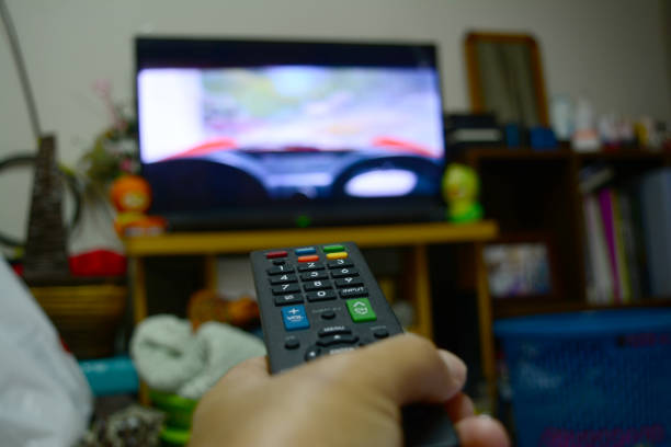 istock remote control in hand and television monitor 827497974