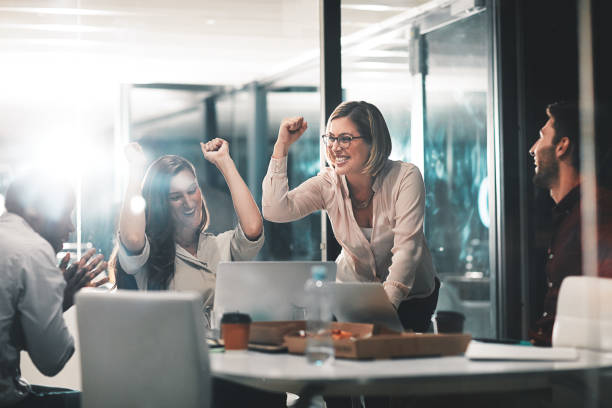 Those who work hard, win Shot of colleagues celebrating during a meeting in a modern office worker working stock pictures, royalty-free photos & images