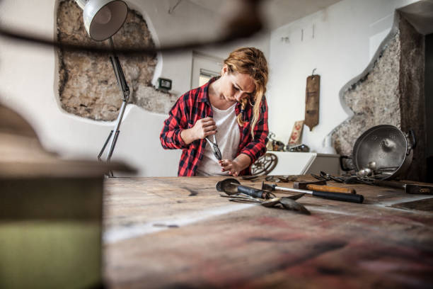 istock Young Creative Woman Creating Art with Screwing Spoons 827499570