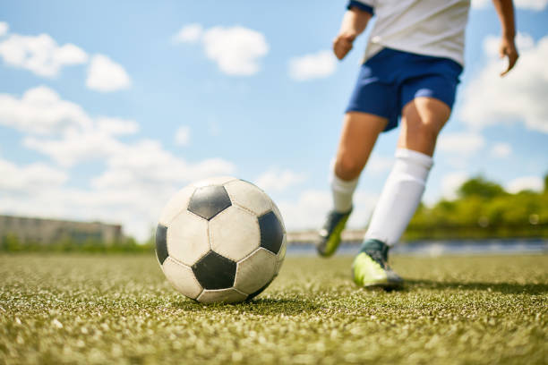 istock Boy Kicking Ball in Football 827507384