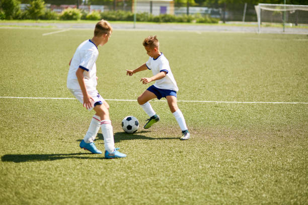 istock Boys Playing Football on Field 827507422