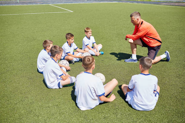 istock Coach Teaching Junior Football Team 827507458