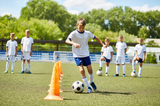 jugador de fútbol junior en práctica - campeonato deportivo juvenil fotografías e imágenes de stock