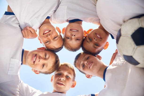 istock Junior Football Team Huddling Before Match 827507512
