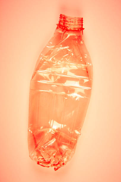 istock Crushed plastic bottle with orange background. Recycled garbage. 827507678