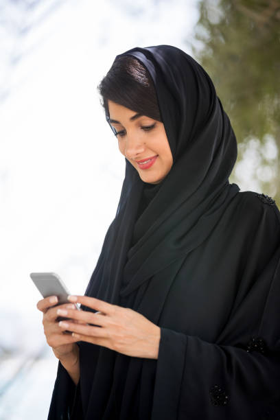 アラブの女性テキスト メッセージング - vertcal ストックフォトと画像
