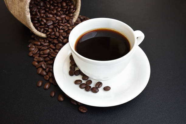 istock Coffee cup and coffee beans on a dark background. 827514304
