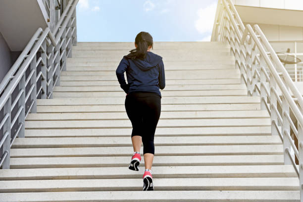 istock Young exercise woman running alone up stairs 827514326