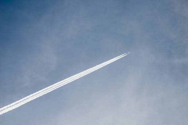 istock Aircraft in cloudy sky with trail 827514538