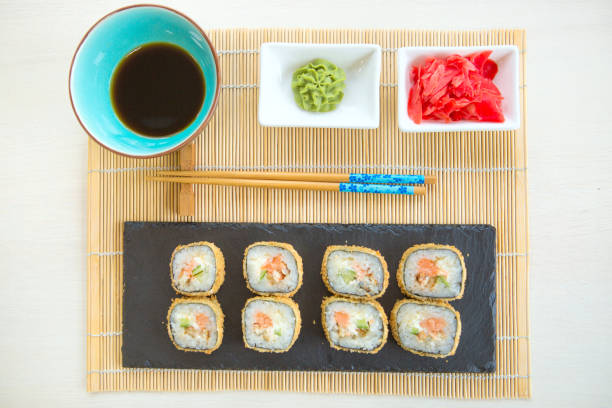 istock Sushi rolls on black slate surface. Japanese food. Hot fried Sushi Roll 827516374