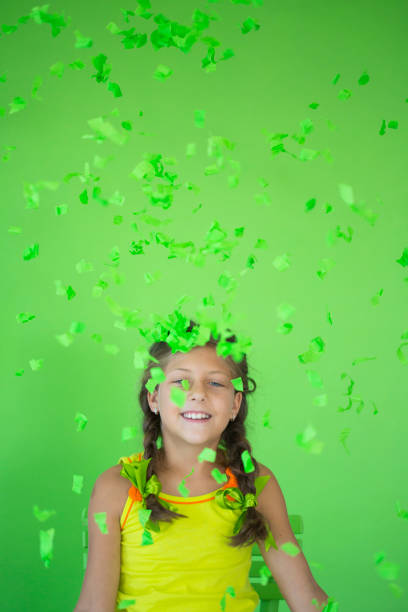 istock Cute girl blowing out confetti 827520772