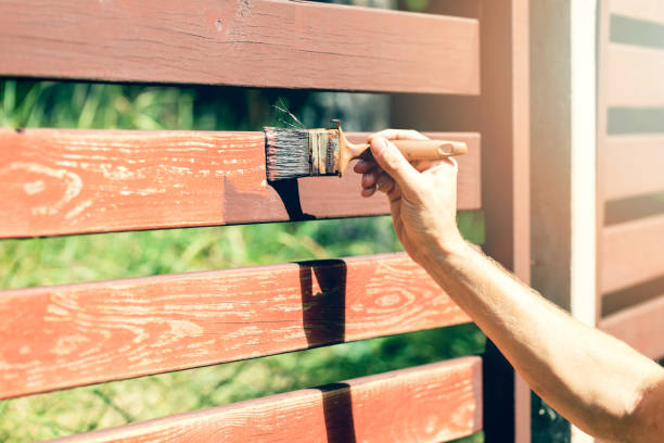 mão com cerca de madeira de pincel pintura com tinta marrom - fence wood stained paint - fotografias e filmes do acervo