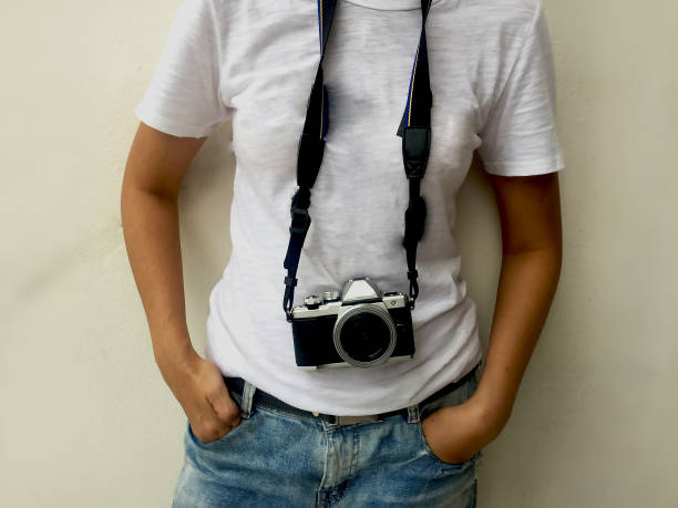 the lady in white t-shirt is hanging the camera and her hand is in blue jeans pocket,in abstract art design,vintage style,art design,blurry light around.