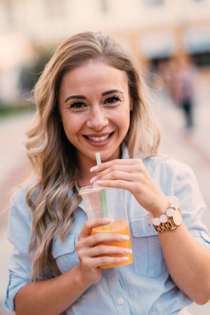 istock Woman drinking juice outdoors 827527268