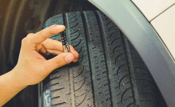 Measuring tread wear on a tire on a car.Safe to use on a daily basis. stock photo