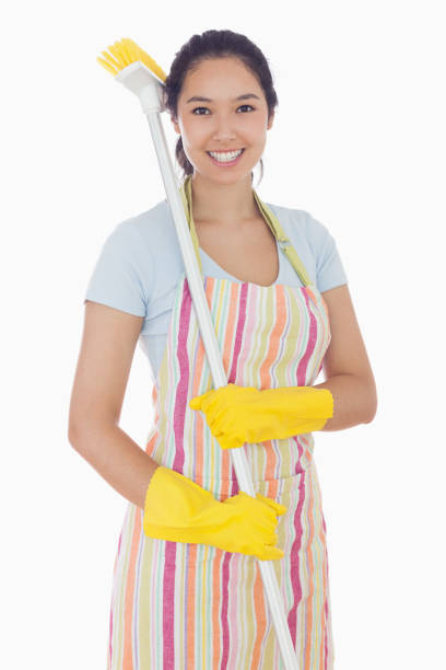 istock Smiling woman with a broom on her shoulder 827529116