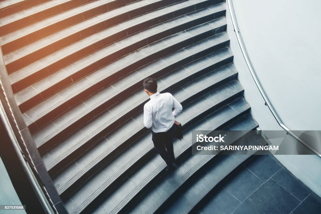 Businessman running fast upstairs Growth up Success concept Staircase Stock Photo