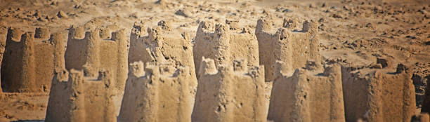 castelli di sabbia al crepuscolo - sandcastle beach norfolk sand foto e immagini stock