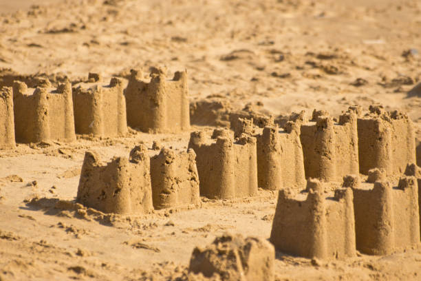 castelli di sabbia al crepuscolo - sandcastle beach norfolk sand foto e immagini stock